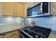 Modern kitchen with stainless steel microwave, range top, and light wood cabinetry at 3768 N 162Nd Ln, Goodyear, AZ 85395