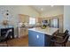 Kitchen with large island, stainless appliances, light wood cabinets, mosaic backsplash, and stylish barstool seating at 3768 N 162Nd Ln, Goodyear, AZ 85395