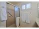 Shower featuring neutral tile, safety bar, and a sliding glass door with a towel rack at 3768 N 162Nd Ln, Goodyear, AZ 85395