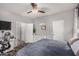 Neutral-toned bedroom with ceiling fan, white dresser, and wood-look floors, flooded with natural light at 41260 N Salix Dr, San Tan Valley, AZ 85140