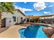 Sparkling backyard pool with a rock waterfall and a shaded patio perfect for outdoor relaxation at 41260 N Salix Dr, San Tan Valley, AZ 85140