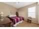 Bedroom with a red-striped bed, ceiling fan, and a sunlit window at 4189 E Sandy Way, Gilbert, AZ 85297