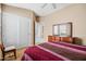 Bedroom featuring a red-striped bed, mirror, closet, and a sunlit window at 4189 E Sandy Way, Gilbert, AZ 85297