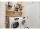 A well-organized laundry room with shelving and front loading washer and dryer at 4189 E Sandy Way, Gilbert, AZ 85297