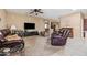 Inviting living room with large TV, comfortable seating, and a ceiling fan at 4189 E Sandy Way, Gilbert, AZ 85297