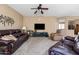 Comfortable living room with leather sofas, ceiling fan, and neutral decor at 4189 E Sandy Way, Gilbert, AZ 85297