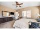 Well lit primary bedroom with a ceiling fan, dresser, and a view of the backyard at 4189 E Sandy Way, Gilbert, AZ 85297