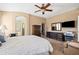 A cozy primary bedroom with a ceiling fan, a television, and an ensuite bathroom at 4189 E Sandy Way, Gilbert, AZ 85297