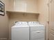 Functional laundry room featuring a side-by-side washer and dryer and ample shelving for convenient storage at 4251 N Golf Dr, Buckeye, AZ 85396