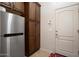 Mud room showing wooden cabinets, and a stainless steel refrigerator at 4251 N Golf Dr, Buckeye, AZ 85396