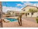 Backyard with a pool, small palm trees and a charming two-story home in the background at 4255 E Cloudburst Ct, Gilbert, AZ 85297