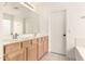 Bright bathroom with dual sinks, vanity with wood cabinets and white tile flooring at 4255 E Cloudburst Ct, Gilbert, AZ 85297