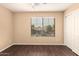 Bright bedroom features wood-look floors, a ceiling fan, and a window with blinds at 4255 E Cloudburst Ct, Gilbert, AZ 85297