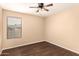 Neutral bedroom with wood-look floors, ceiling fan, and window with horizontal blinds at 4255 E Cloudburst Ct, Gilbert, AZ 85297