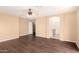 Neutral bedroom with wood-look floors, ceiling fan, attached bathroom, and open doorway at 4255 E Cloudburst Ct, Gilbert, AZ 85297