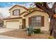 Two-story beige home with desert landscaping, a two-car garage, and a tree in the front yard at 4255 E Cloudburst Ct, Gilbert, AZ 85297