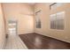 Neutral living room with dark wood flooring, high ceilings, and natural light from large windows at 4255 E Cloudburst Ct, Gilbert, AZ 85297