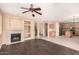 Open-concept living room with fireplace, wood flooring, and view of the kitchen and staircase at 4255 E Cloudburst Ct, Gilbert, AZ 85297