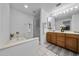 Bright bathroom featuring a soaking tub, glass-enclosed shower, and wood vanity with double sinks at 45 E 9Th Pl # 12, Mesa, AZ 85201