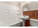 Bathroom featuring a pedestal sink, shower-tub combo, and tiled accents at 4601 S 21St St, Phoenix, AZ 85040