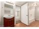 Bathroom view showcasing wood vanity, large mirror, and a shower-tub combo at 4601 S 21St St, Phoenix, AZ 85040