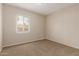 A neutral bedroom shows light brown carpet, paint, baseboards, and a window at 4601 S 21St St, Phoenix, AZ 85040