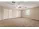 Spacious carpeted bedroom features neutral paint, ceiling fan, and a large closet at 4601 S 21St St, Phoenix, AZ 85040