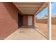 Covered patio area featuring a doorway to the home and brick walls at 4601 S 21St St, Phoenix, AZ 85040