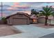 Charming single-story home with a well-maintained yard and spacious driveway, set against a colorful evening sky at 474 W Smoke Tree Rd, Gilbert, AZ 85233