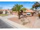 Well-maintained home with desert landscaping, mature palm tree, and a spacious driveway leading to the garage at 474 W Smoke Tree Rd, Gilbert, AZ 85233