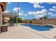 Backyard pool featuring concrete deck, integrated spa, water feature, and tasteful string lights at 474 W Smoke Tree Rd, Gilbert, AZ 85233