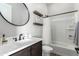 Clean bathroom featuring a bathtub, dark wood cabinets, and a round mirror at 5513 S Coyote Cyn, Mesa, AZ 85212