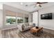 Bright living room with stylish decor, ceiling fan, wood floors, and view of the pool at 5513 S Coyote Cyn, Mesa, AZ 85212