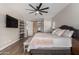 Comfortable main bedroom showcasing a bed with decorative pillows, wood floors, and a modern ceiling fan at 5513 S Coyote Cyn, Mesa, AZ 85212