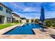 Lush backyard featuring a sparkling pool, artificial grass, stone decking, and a view of the home at 5513 S Coyote Cyn, Mesa, AZ 85212