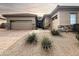 Home exterior featuring a three car garage, desert landscaping, stone accents, and a brick paver driveway at 6039 E Sienna Bouquet Pl, Cave Creek, AZ 85331