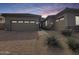 Beautiful home exterior featuring a three car garage, stone accents, desert landscaping, and a brick paver walkway at 6039 E Sienna Bouquet Pl, Cave Creek, AZ 85331