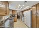 Traditional kitchen with wood cabinets, dual basin sink, tile floors, and white appliances at 617 S Palo Verde Way, Mesa, AZ 85208