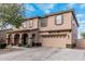 Charming two-story home featuring a two-car garage and inviting front porch with stone pillars and desert landscaping at 6208 N 78Th Dr, Glendale, AZ 85303