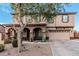 Charming two-story home featuring a two-car garage and inviting front porch with stone pillars and a decorative tree at 6208 N 78Th Dr, Glendale, AZ 85303