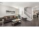 Bright living room with gray sofas, mirrored coffee table, wood-look floors and staircase at 6208 N 78Th Dr, Glendale, AZ 85303