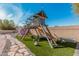 Fun backyard with a custom wooden playset, swings, slide, climbing area and artificial grass at 6208 N 78Th Dr, Glendale, AZ 85303