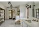 Bright bathroom featuring tiled floors, standalone tub, marble counters, and a double door to the outside at 6737 E Taza Way, Paradise Valley, AZ 85253