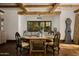 Elegant dining room with exposed beams, wood floors, and a large window framing the outdoor scenery at 6737 E Taza Way, Paradise Valley, AZ 85253