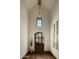 Charming foyer featuring a high ceiling with an antique chandelier and a stained wood front door at 6737 E Taza Way, Paradise Valley, AZ 85253