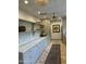 Custom laundry area featuring gray cabinets, marble counters, open shelving, and brick-style flooring at 6737 E Taza Way, Paradise Valley, AZ 85253