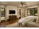 Spacious main bedroom with hardwood floors, ceiling fan, wooden windows, and decorative curtains at 6737 E Taza Way, Paradise Valley, AZ 85253