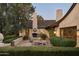 Outdoor living space with a fireplace, dining table, and lush greenery around the well manicured patio at 6737 E Taza Way, Paradise Valley, AZ 85253