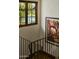 Staircase with an outside window overlooking the pool and lush landscaping at 6737 E Taza Way, Paradise Valley, AZ 85253