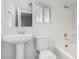 Cozy all-white bathroom featuring a pedestal sink and tub-shower combo at 7022 N 26Th Dr, Phoenix, AZ 85051